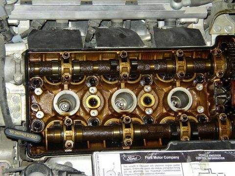 1993 Ford Taurus - The engine's valve cover is off, revealing the camshafts and valve train components.
