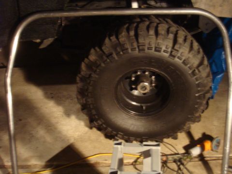1992 Ford Bronco - A close-up view of a tire and roll cage on a 1992 Ford Bronco, supported by a jack stand.