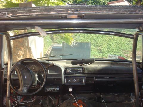 1992 Ford Bronco - The interior of a 1992 Ford Bronco shows a roll cage installed over the dashboard and seats.