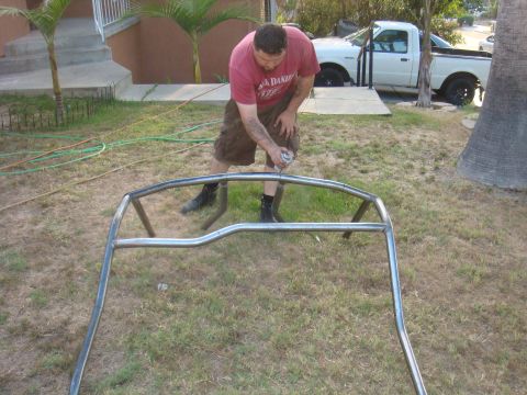1992 Ford Bronco - Man fabricating a custom roll cage in a grassy yard with a white pickup truck in the background.