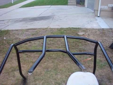 1992 Ford Bronco - A black roll cage is shown outdoors, with a driveway and house in the background.