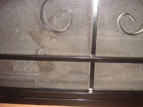 1992 Ford Bronco - Close-up of a decorative black metal fireplace screen with mesh.