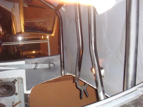 1992 Ford Bronco - Close-up of the interior of a vehicle, focusing on roll cage tubing and a seatbelt.