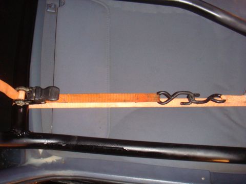 1992 Ford Bronco - Close-up of a vehicle's interior roll cage with a securing strap and ratchet. The year is not discernible from the image.