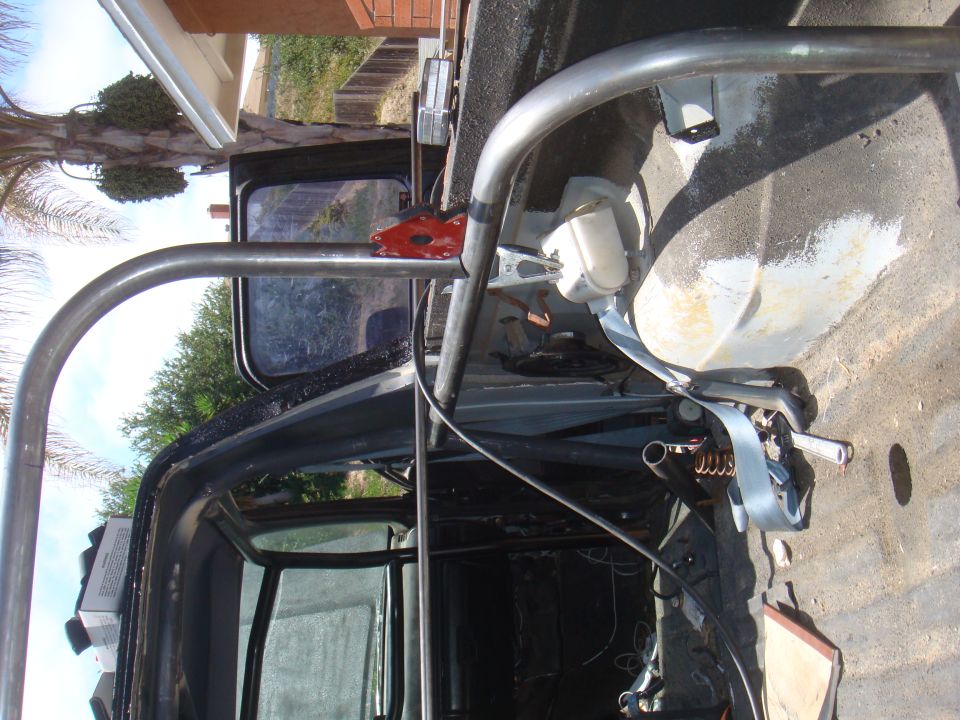 Roll cage and seatbelt inside a dark vehicle interior
