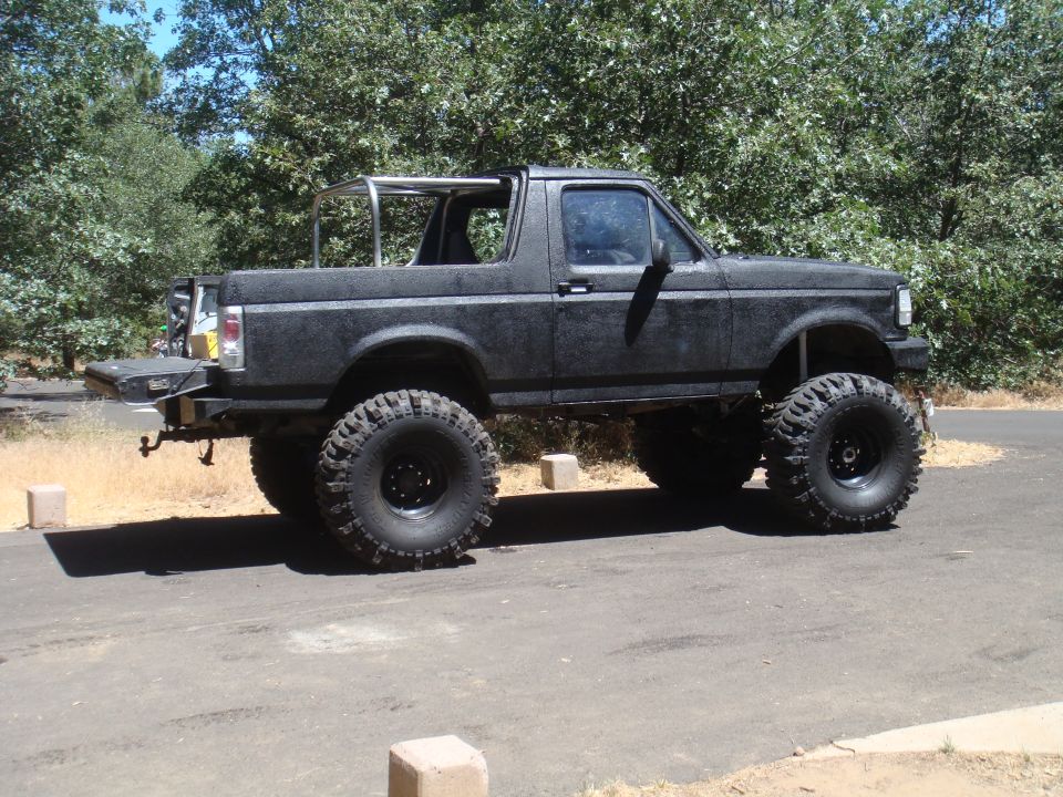 Lifted black Ford Bronco with large tires parked on asphalt