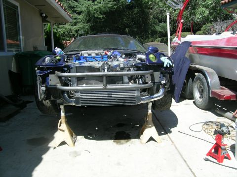 1995 Ford Probe - Car is on jack stands with front bumper removed, showing the engine and intercooler.
