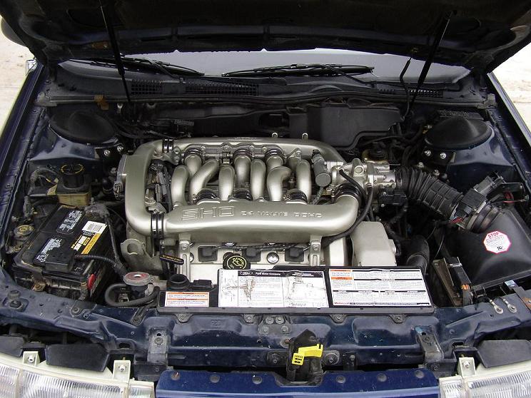 Dark blue 1993 Ford Taurus SHO engine bay with V8 engine, battery, and hood open