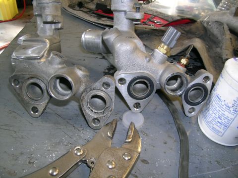 1995 Ford Probe - Close-up of two automotive parts, possibly intake manifolds, with a pair of locking pliers and a can of fluid in the background.