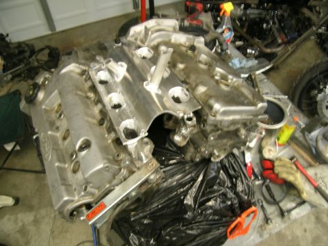 1995 Ford Probe - A disassembled engine block and its intake manifold are shown in a garage setting.