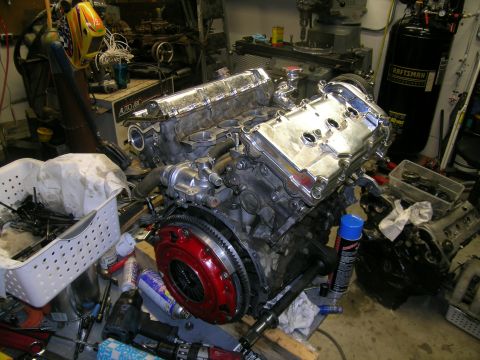 1995 Ford Probe - Engine assembly with a prominent red clutch is shown in a cluttered workshop environment.