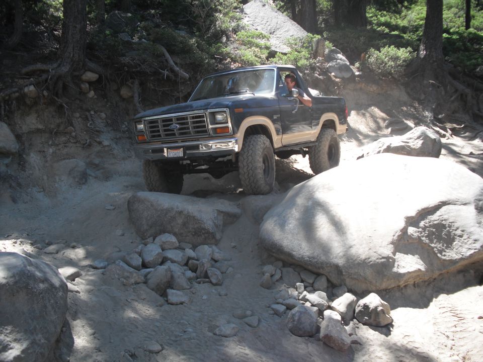 Dark blue and tan Ford F-150 pickup truck on a rocky trail