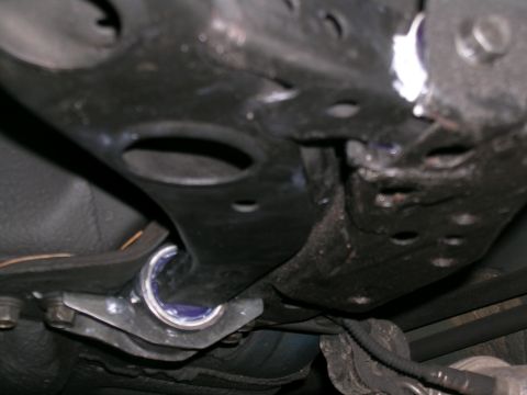 1995 Ford Probe - Close-up view of a car's undercarriage, focusing on suspension components and blue bushings.