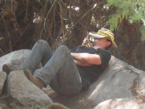1991 Ford Bronco - A person takes a break, resting on large rocks amidst trees and foliage.