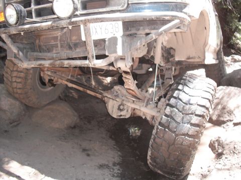 1991 Ford Bronco - Front suspension of a 1991 Ford Bronco navigating rough, rocky terrain.