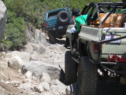 1991 Ford Bronco - Two off-road vehicles navigate a challenging rocky trail.