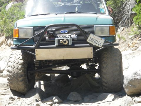 1991 Ford Bronco - This modified off-road vehicle is equipped with a winch and large tires, suggesting it is built for terrain.