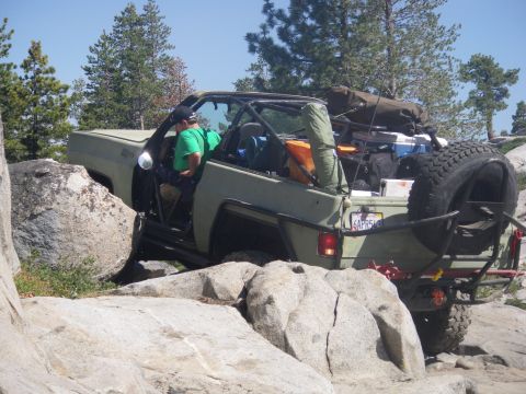 1991 Ford Bronco - Off-road SUV is carefully maneuvering over large rocks on a trail.