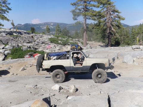 1991 Ford Bronco - This modified SUV navigates a challenging rocky trail, equipped for off-road adventure.