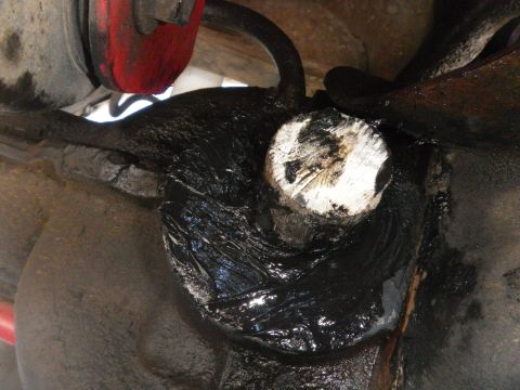 1991 Ford Bronco - This photo shows a heavily greased suspension part with a white-capped bolt, likely requiring maintenance.