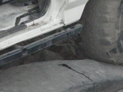 1991 Ford Bronco - Vehicle's running board over rough, rocky terrain.