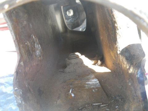 1991 Ford Bronco - This image shows a heavily rusted, hollow metal component, possibly part of a vehicle's frame.
