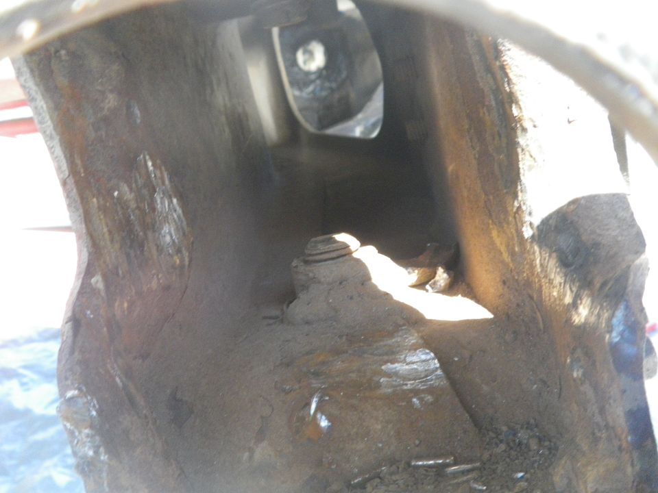Close-up of heavily rusted, hollow metal structure with a bolt visible inside
