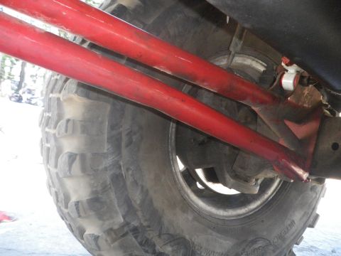 1991 Ford Bronco - Close-up view of red suspension components and a tire, with Supermotors branding visible at the bottom.