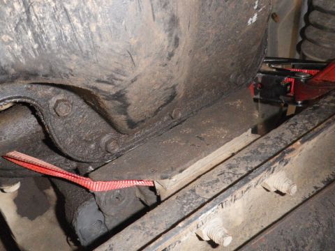1991 Ford Bronco - A close-up view of a vehicle's undercarriage, showing mechanical components and a red strap. The Supermotors.net logo is visible in the low…