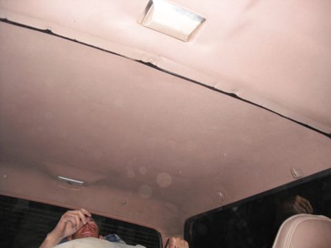 1991 Ford Bronco - The interior of a vehicle is shown, focusing on the headliner and dome light, with a person visible in the background.