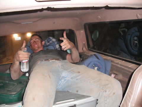 1991 Ford Bronco - Man relaxing in the back of a vehicle, giving a thumbs up.