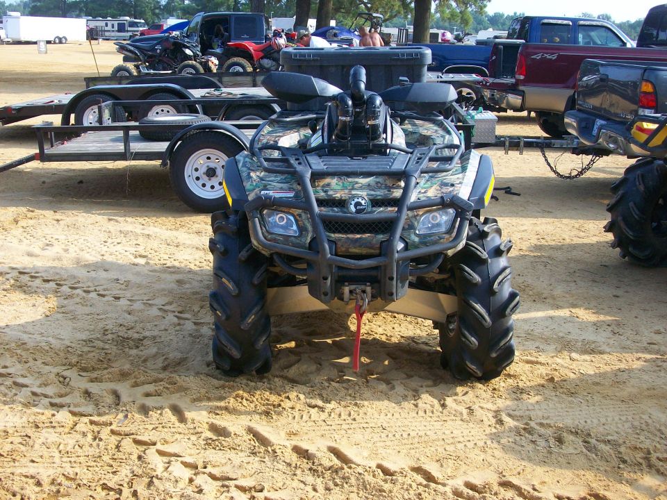Camo Can-Am ATV with snorkel kit, mud tires and front winch parked on sand