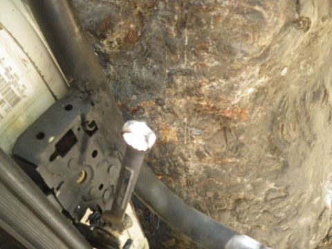 1991 Ford Bronco - Underside view of a vehicle, heavily affected by rust and dirt, with visible frame components.