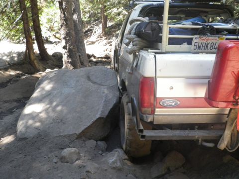 1991 Ford Bronco - This 1991 Ford Bronco is carefully maneuvering around a large rock on a forest path.