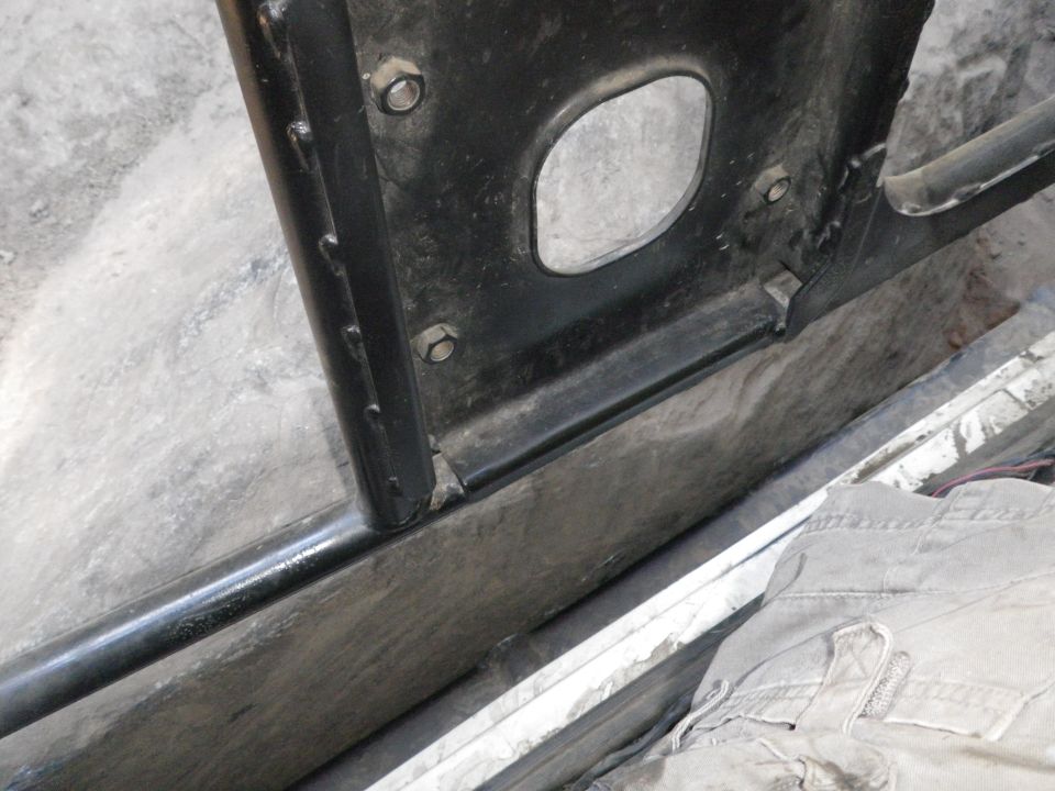 close-up of black metal door frame and rocker panel, some dirt visible