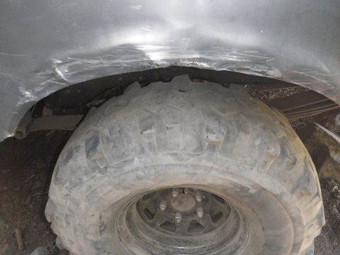 1991 Ford Bronco - Close-up of a dented wheel well and a large tire on a vehicle, with a SuperMotors logo visible.