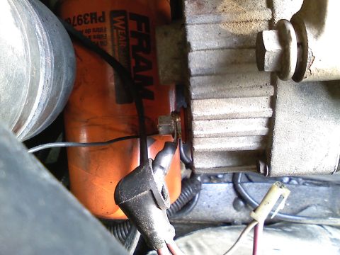 1990 Ford Bronco - Detail of engine components including an oil filter and alternator, with visible wiring and mounting hardware.
