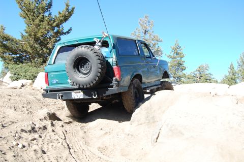 1993 Jeep Wrangler - Ford Bronco navigating rocky terrain off-road.