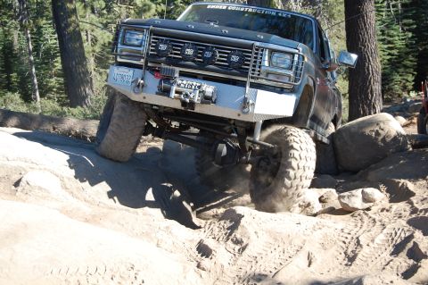 1993 Jeep Wrangler - This modified truck is tackling a challenging rocky trail, demonstrating its off-road capabilities.