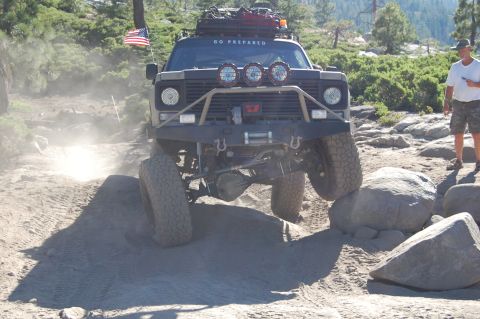 1993 Jeep Wrangler - This heavily modified off-road vehicle tackles a challenging rocky trail, with "GO PREPARED" visible on its windshield.