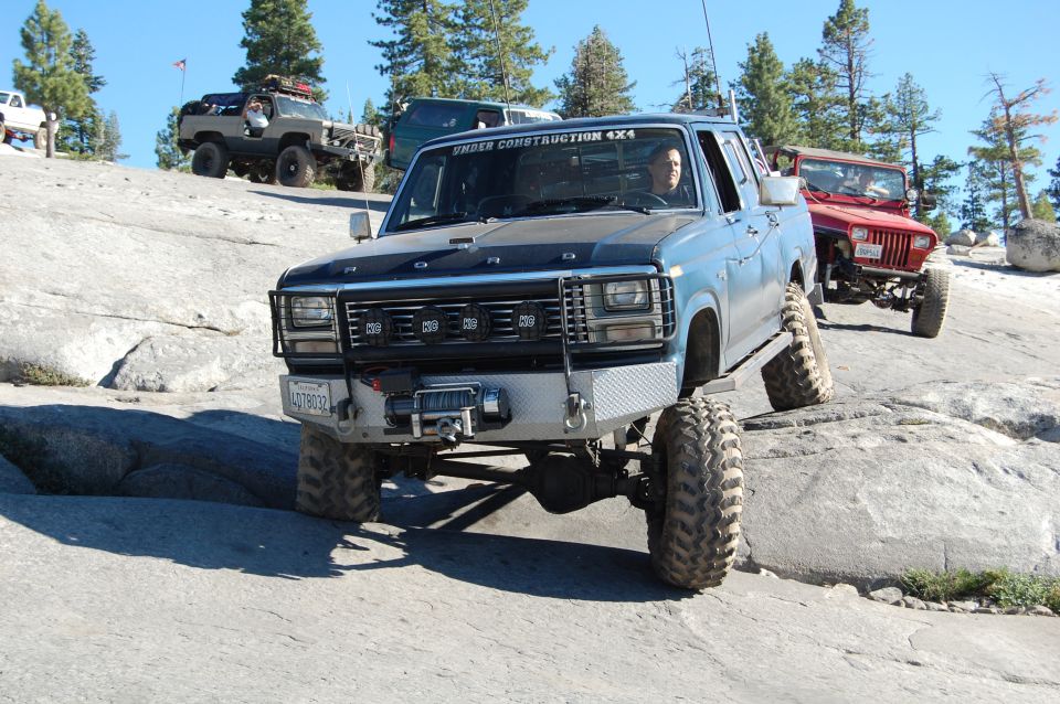 Blue pickup truck with custom bumper and winch, off-roading
