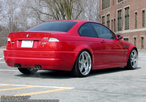 1998 Ford Crown Victoria - A red BMW M3 coupe is viewed from the rear three-quarter angle in front of a brick building.