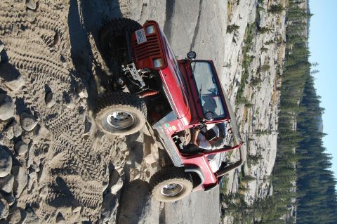 1993 Jeep Wrangler - This red 1993 Jeep Wrangler navigates a challenging rocky terrain, its off-road capabilities.