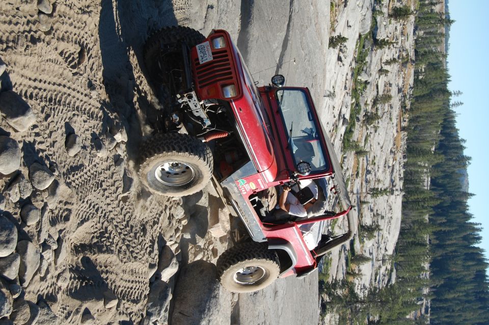 Red 1993 Jeep Wrangler off-roading on a rocky trail