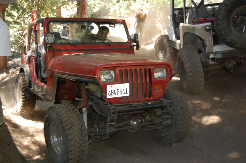 Red 1993 Jeep Wrangler with a license plate reading 6BQP541 on a dusty trail