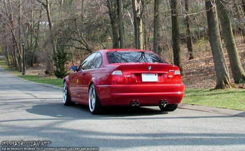 1998 Ford Crown Victoria - Red BMW M3 coupe seen from the rear on a tree-lined road.