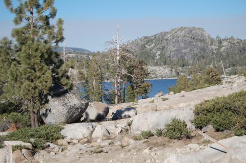 1993 Jeep Wrangler - A scenic view of a mountain lake surrounded by rocks and trees under a clear blue sky.