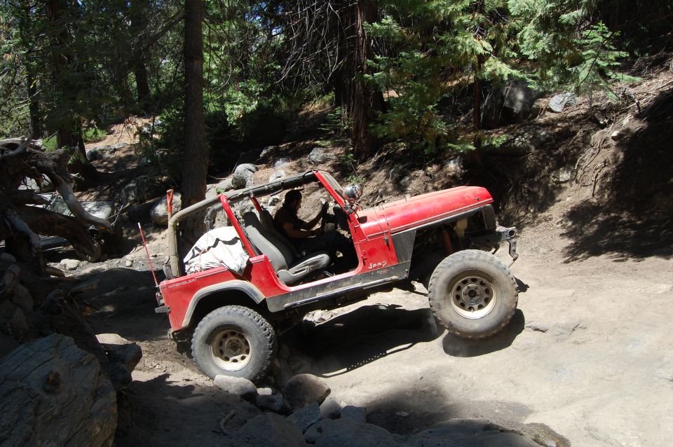 Red 1993 Jeep Wrangler navigating a rocky off-road trail