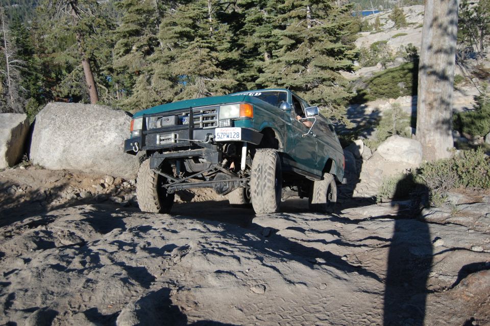 Green Ford Bronco on rocky trail, front winch visible. License plate 52FW128