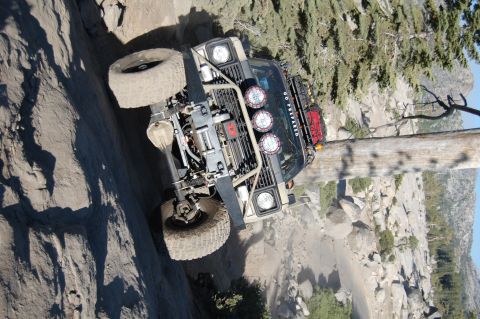 1993 Jeep Wrangler - This heavily modified off-road vehicle navigates a challenging rocky ascent, its robust suspension and off-road capabilities.